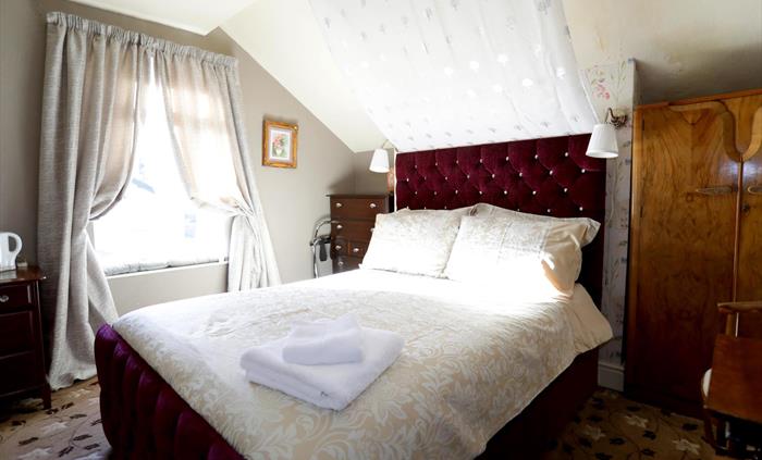 Relax on the window seat, where you can watch the world pass by or delve into your favorite novel in this special room adorned with charming eaves.